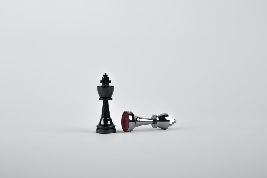 Two Silver Chess Pieces on White Surface