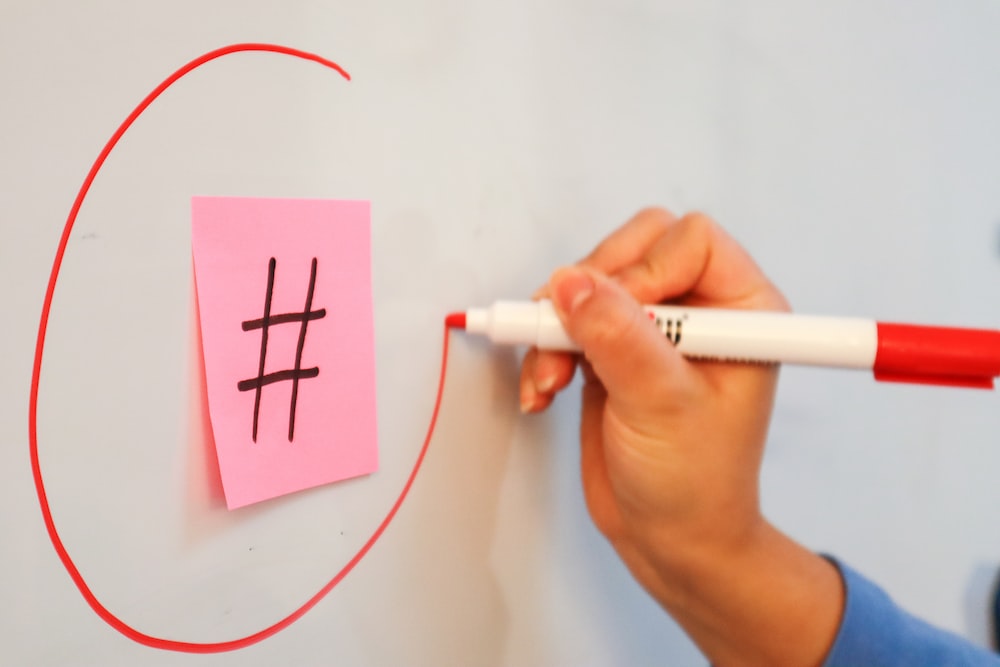 a person writing on a piece of paper with a marker