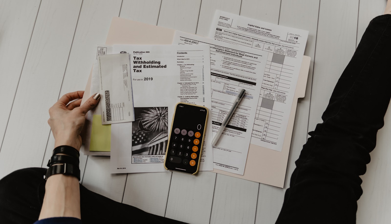 IG Marketer analyzing tax forms on a mobile phone screen with various sections and text related to tax withholding and capital gains for 2018.