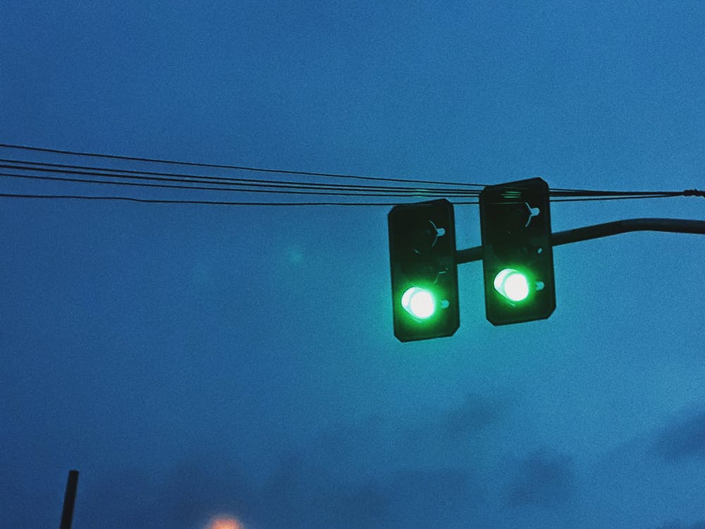 Green traffic light against dark sky
