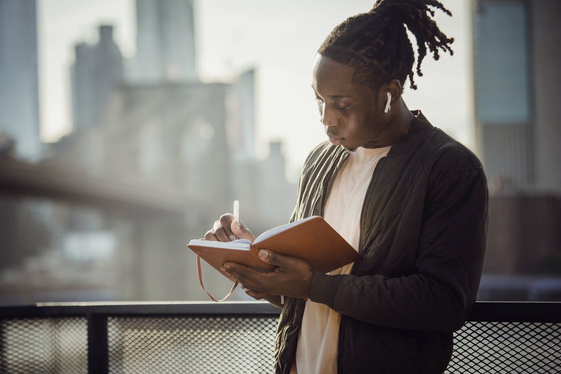 Free Man Writing On A Notebook Stock Photo